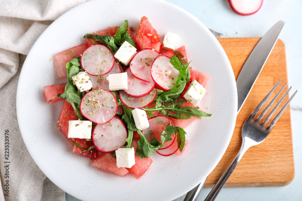Plate with delicious watermelon salad on table, top view