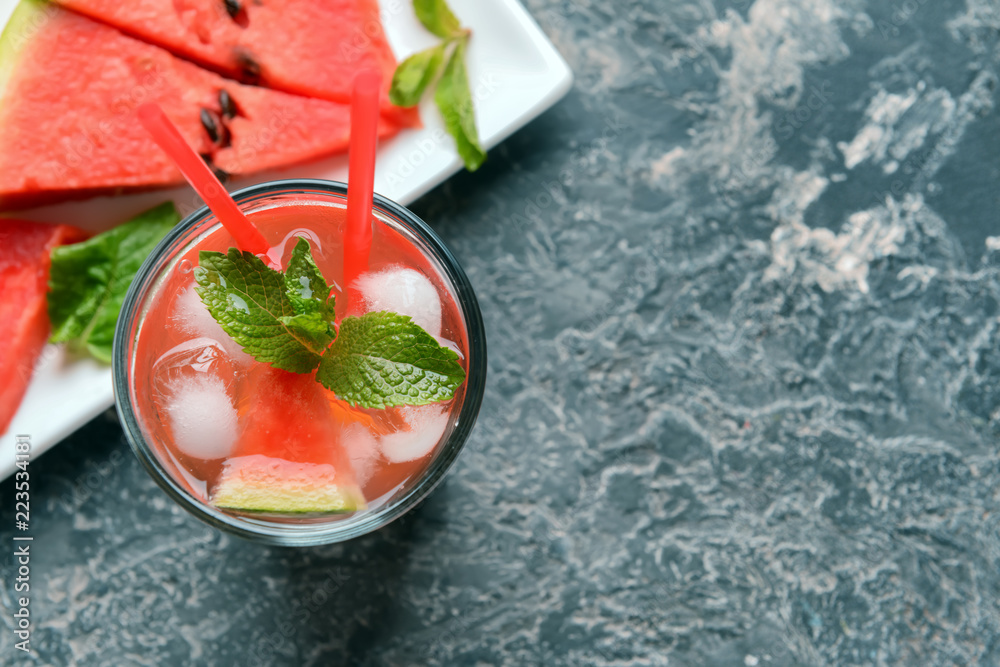 Glass of tasty cold watermelon lemonade on dark table