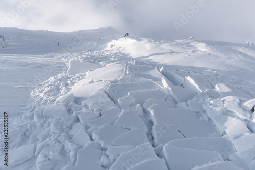 Fotomural Snow avalanche in winter mountains. Danger extreme concept