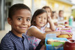 © Monkey Business - Young boy and girl at school lunch table smiling to camera
