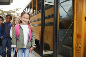 Elementary school kids waiting to board the school bus