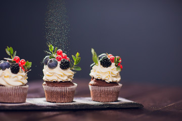 muffin decoration .No powdered sugar. woman confectioner throws powder