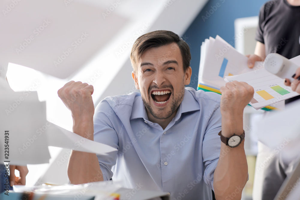 Stressed businessman with a lot of work in office