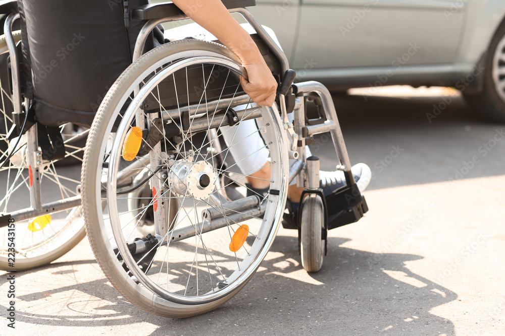 Woman in wheelchair next to her car