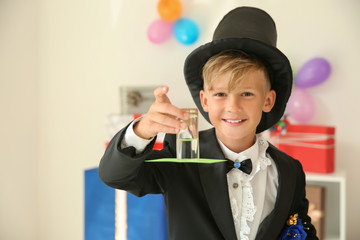 Cute little magician showing trick indoors