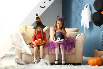 cute little girls in halloween costumes at home