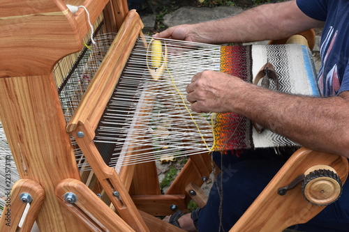 Fotografie, Obraz Hands of middle-aged man - craftsman weaver - working on wooden handloom, Etara