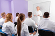 © JackF - Group of medical students attentively listening to lecture of female teacher in classroom