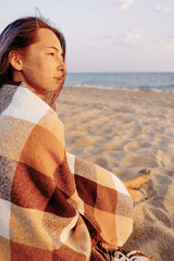 Poster - Young woman sitting on sand beach.