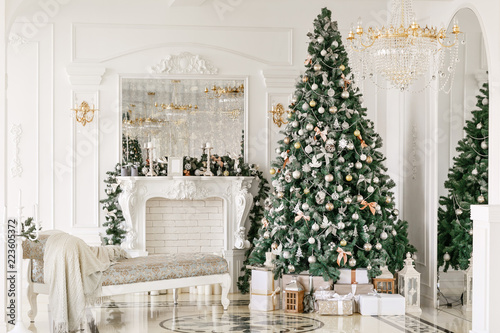 Zdjęcie XXL prezenty na choince. Świąteczny poranek. klasyczne luksusowe apartamenty z białym kominkiem, sofą, dużymi oknami i żyrandolem.
