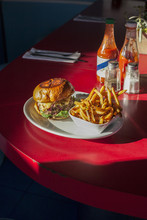 Burger With French Fries Served On Plate At Restaurant