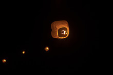 Low Angle View Of Illuminated Lanterns Flying Against Sky At Night