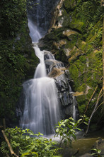 View Of Waterfall Over Rocks In Forest