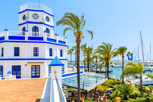 Beautiful Lighthouse Building And Palm Trees In Estepona Port On Costa Del Sol Coast, Spain