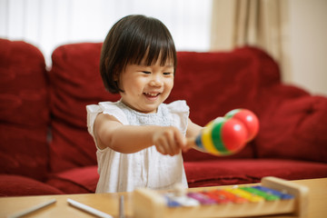 baby girl play maracas at home