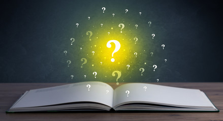 Yellow question marks hovering over open book 