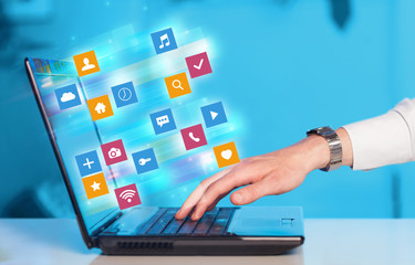Poster - Hand using laptop with colorful fast moving application icons and symbols concept
