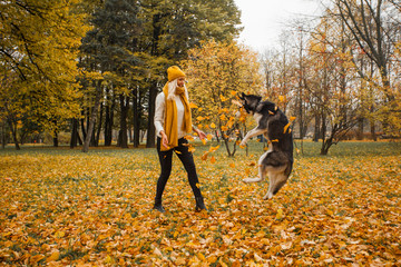 Happy woman and dog husky playing together outdoor