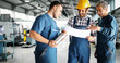 © NDABCREATIVITY - Team Of Engineers Having Discussion In Factory