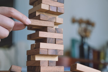 Closeup image of a hand holding and playing Tumble tower wooden block game