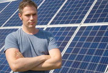 Man standing in front of solar panels. Renewable energy.