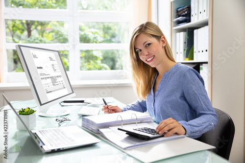 Fotomural Young Businesswoman Calculating Bill In Office