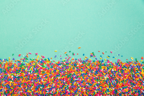 Fotografía Colorful sprinkles on bottom of green background