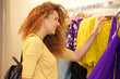 © mimagephotos - attractive young woman shopping for clothes in store