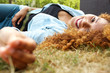 © mimagephotos - attractive young woman lying on grass outside