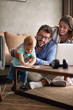 © luckybusiness - Parents with baby working from home using laptop.