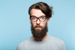 yuck. disgusted revolted bearded hipster guy wearing cat eye glasses. stylish modern fashionist. portrait of a geeky quirky eccentric man on blue background.