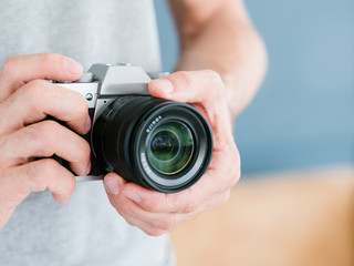 photography professional equipment. modern electronics technology for creating beautiful shots. unrecognizable man holding photo camera in hands.