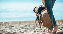 Woman Traveler Stand On The Sand Beach And Holding Backpack. Concept Of Travel.