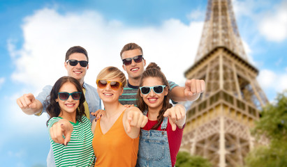 Wall Mural - friendship, summer and people concept - group of happy smiling friends in sunglasses pointing at you over eiffel tower background