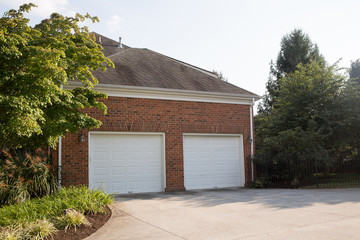 Brick House with Two Car White Garage Doors