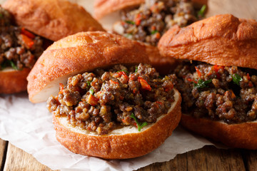 South African food: deep-fried vetkoek sandwich with meat curry close-up. horizontal