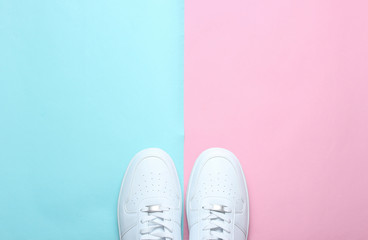 Wall Mural - Fashionable white sneakers on a colored pastel background, minimalism, top view, creative layout.