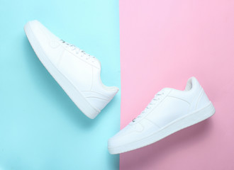 Wall Mural - Fashionable white sneakers on a colored pastel background, minimalism, top view, creative layout, step.