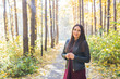 © satura_ - People, season and nature concept - Young woman walking in autumn park