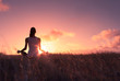 Leinwandbild Motiv Young woman meditating outdoors at sunset. 