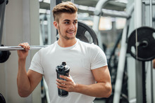 Athlete Man Having A Snack With Protein Cocktail In Shaker Over Gym Machine Background