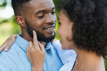 African-american woman touching husband beard while walking