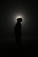 Silhouette In The Dark, Head Leaning Backwards With Open Mouth. Light Behind Head.