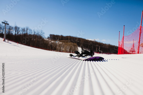Fotografía Bottom view on empty ski slope and equipment for snowboarding