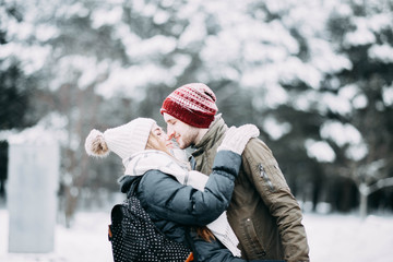 Wall Mural - happy young people, couple in winter snowy forest. beautiful lovers having fun.