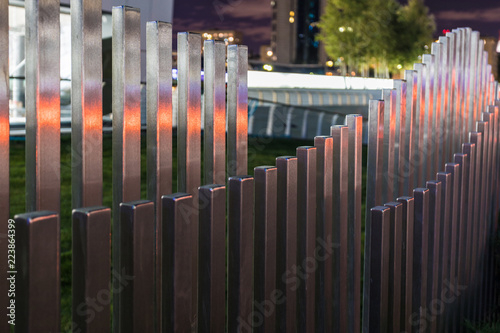 Fotografie, Obraz The wavy wood fence near the road in the colours of car traffic lights