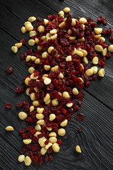 Wall Mural - Healthy snack of Dried cranberries and macadamia nuts in a ceramic bowl on rustic wooden table