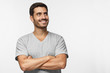 © Damir Khabirov - Portrait of young man with crossed arms and dreamy cheerful expression, thinking, isolated on gray background with copy space for your ads