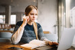 © Oleksii - Young concentrated university student studying at modern library. Cheerful caucasian woman with beautiful blue eyes sitting in loft cafe, planning working process online, very busy. Exam preparation.