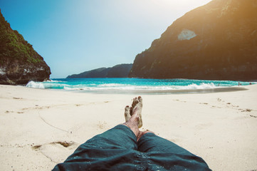 Man on vacation relaxing at the beach. Pov view